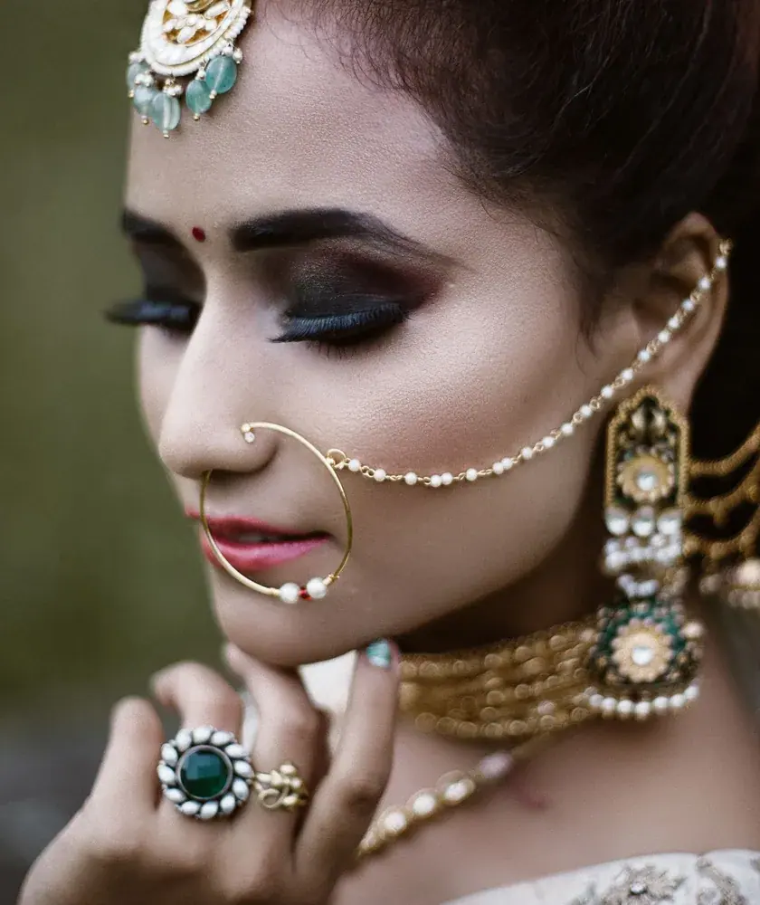 Bride wearing a kundan necklace, nath and maang tikka
